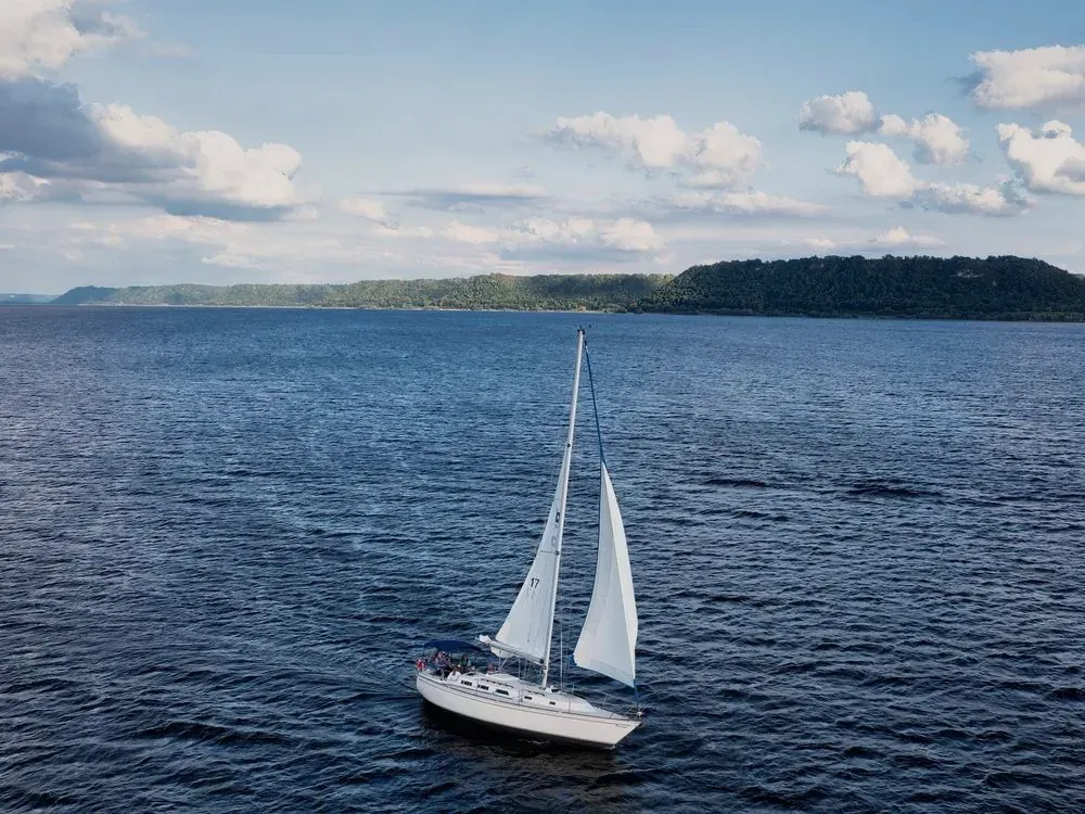 Velero navegando a vela en mar abierto, visto desde el aire